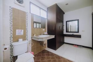 a bathroom with a toilet and a sink and a mirror at Monaburi Boutique Resort in Rawai Beach +37 photos