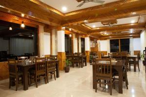 a dining room with wooden tables and chairs at Shree Ganga Cottages in Raogi