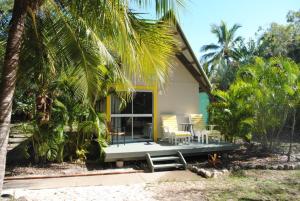 a house with a porch with chairs and palm trees at Great Keppel Island Holiday Village in Great Keppel