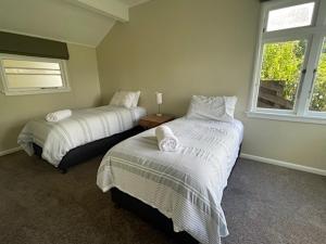 a bedroom with two beds and a window at Tiro Tai - Coastal Views in Tahunanui +24 photos
