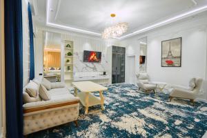 a living room with white furniture and a fireplace at FIRDAVS HOTEL in Navoi +25 photos