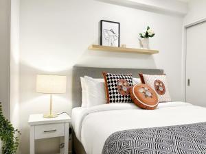 a bedroom with a white bed with pillows at Serene Cityscape 1B Apt Near Skytower vs Gym Pool Sauna in Auckland +20 photos
