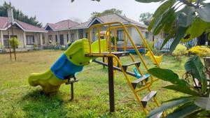 a playground with a slide in a yard at Windchime Cottages in Alibaug