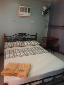 a bedroom with a bed with two towels on it at Sunset Vista Sea Front Guest House in Camotes Islands