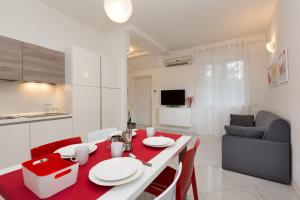 Una cocina y una sala de estar con una mesa y sillas rojas. en Residence Klima House de Vilos, en Arco