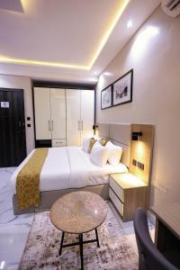 a hotel room with a large bed and a table at Ringruby Hotel, Oduduwa Way in Ikeja