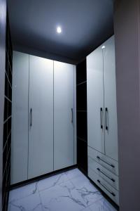 a dressing room with white cabinets and a ceiling at Ringruby Hotel, Oduduwa Way in Ikeja