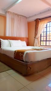 a large bed in a room with a window at Savannah Paradise Hotel in Makindu +40 photos