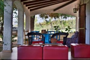 a patio with red chairs and a table and a porch at Il Tremolar Della Marina in Casalbordino