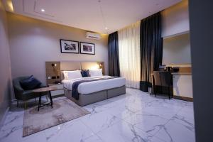 a hotel room with a king sized bed and a desk at Ringruby Hotel, Oduduwa Way in Ikeja