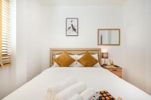 una camera da letto con un grande letto bianco con cuscini dorati di Gift Pool Villa Khaoyai เขาใหญ่ บ้านพักเขาใหญ่ พูลวิลล่าเขาใหญ่ a Ban Nong Ka Cha Altre 54 foto