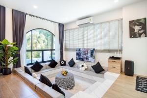 un soggiorno con un divano e una TV di Gift Pool Villa Khaoyai เขาใหญ่ บ้านพักเขาใหญ่ พูลวิลล่าเขาใหญ่ a Ban Nong Ka Cha
