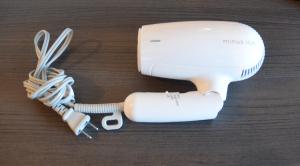 a white hair dryer sitting on top of a table at Hotel Ocean Iwasawa in Hirono