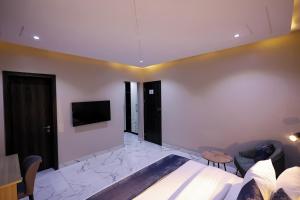 a bedroom with a bed and a tv on a wall at Ringruby Hotel, Oduduwa Way in Ikeja