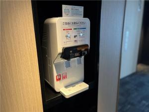 a machine in a wall in a room at JR Kyushu Hotel Blossom Shinjuku in Tokyo
