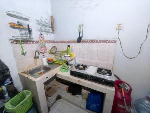 a dirty kitchen with a sink and a sink at Mutiara Babarsari Homestay Jogja in Seturan +7 photos