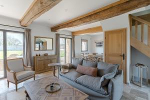 ein Wohnzimmer mit einem blauen Sofa und einem Tisch in der Unterkunft Maison Morny Your Exquisite Retreat near Deauville in Cricquebœuf