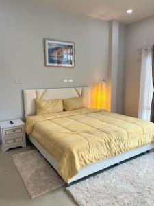 a bedroom with a large bed with a yellow blanket at Cherina Pool Villa2 in Ban Yep Chaeng +30 photos