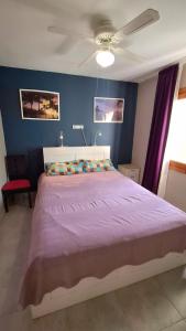 a bedroom with a large bed with a purple blanket at CASA DE LIVIA Vera Playa-bajo in Playas de Vera +29 photos