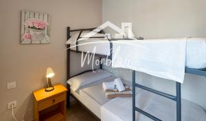 a small bedroom with a bunk bed with white sheets at Ses Orenetes in Cala en Blanes