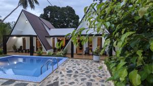 a villa with a swimming pool in front of a house at Palm serenity villa in Tangalle