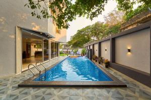 a swimming pool in the backyard of a house at Seven Sands I Forest Pool Villa One I 6 BHK in Lonavala