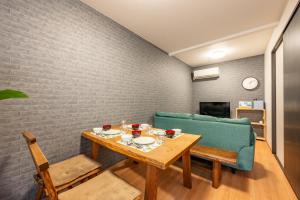 comedor con mesa y sofá azul en BP house 森ノ宮, en Osaka
