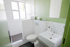 a white bathroom with a toilet and a sink at Never at Home Kloof Street in Cape Town +27 photos