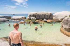 a man standing in the water at a beach at Never at Home Kloof Street in Cape Town