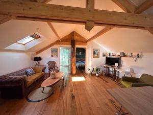 a living room with a couch and a table at Le Loft in Lacanau