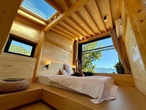 a bedroom in a log cabin with a large window at Black Stone Hilltop Great Wall Lodge & Whisky Lounge in Simataicun