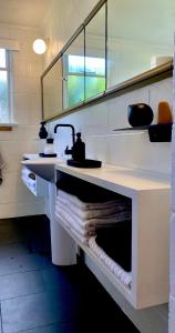 a bathroom with two sinks and a mirror at Midcentury Magic in Marlborough in Blenheim