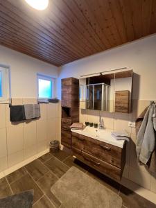 bagno con lavandino e soffitto in legno di Chalet Ester a Bad Hofgastein Altre 37 foto