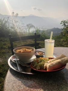 a table with a bowl of food and a bowl of soup and a drink at Into The Wild Pokhara in Kāskī