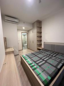 a bedroom with a bed with a checkered blanket at Masterise Center Point 2BR in Gò Công