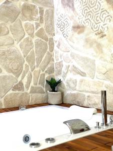 a bathroom with a sink and a stone wall at Pharus Miseni Suites and rooms in Bacoli