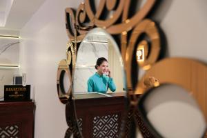 a woman brushing her teeth in front of a mirror at Hanoi Fiesta Central Hotel and Spa in Hanoi +91 photos