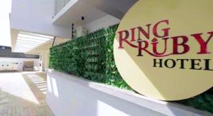 a building with a green wall with a ring riley hotel at Ringruby Hotel, Oduduwa Way in Ikeja