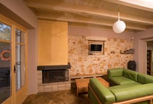 sala de estar con sofá verde y chimenea en Olivia on Sea, en Agios Spiridon, Corfú 69 fotos más