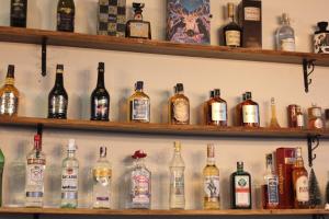 a shelf filled with lots of bottles of alcohol at Jindarin Villas จินดาริน คาเฟ่ in Ban Nong Sarai (1)