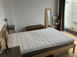 a bedroom with a bed and a bird standing next to a window at Cap Ferret Océan - Réf 52 in Lège-Cap-Ferret