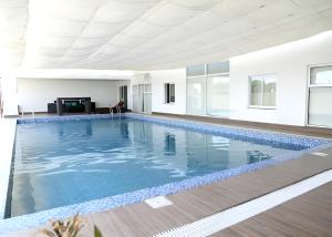 a large swimming pool with blue water in a building at Zameen Opal in Lahore