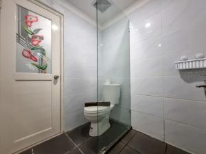 ein Badezimmer mit Toilette und Glastür in der Unterkunft Best Place and Cozy Studio at Altuz Seturan Yogyakarta Apartment By Travelio in Seturan + 9 Fotos