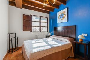 a bedroom with two beds and a blue wall at Fana in Cangas de Onís