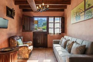 a living room with a couch and chairs and a window at Fana in Cangas de Onís