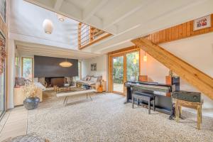 a living room with a piano and a couch at Villa Cap-Ferret, vue bassin-pinède in Lège-Cap-Ferret