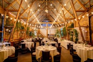 a banquet hall with white tables and chairs at Gård Halltorps hage in Borgholm