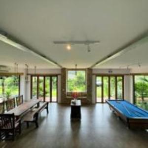 Großes Zimmer mit Billardtisch und Fenstern in der Unterkunft The Cottage Hồ Tràm - Venuestay in Thuận Biên