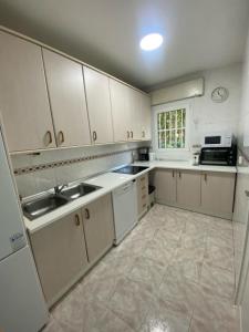 a kitchen with white cabinets and a sink at Casa rural Balcón de Monachil in Monachil