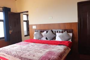 een slaapkamer met een groot bed met een rode deken bij Deodar Cottage - 3BHK Villa by DeodarStays in Mussoorie
